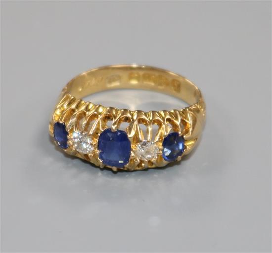 An early 20th century 18ct gold and claw set sapphire and diamond five stone ring, size L.